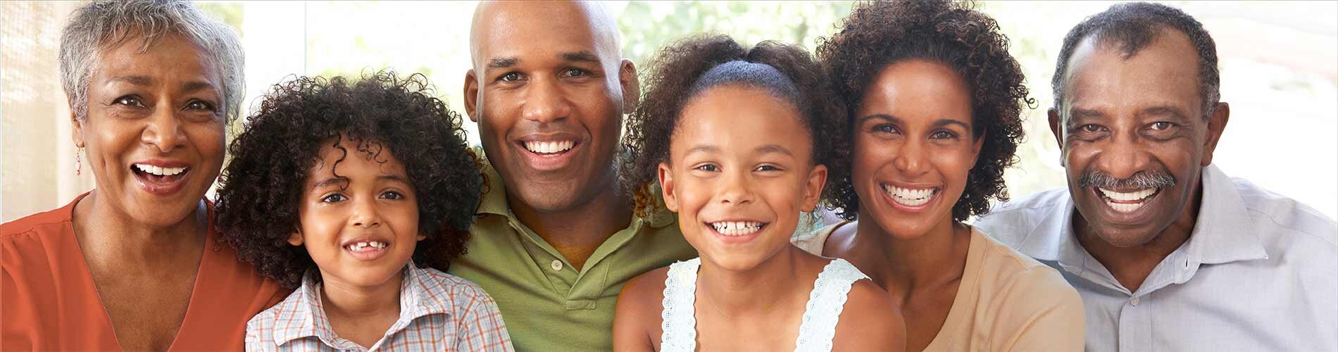 A family of six smile for a photograph inside of their housing unit.