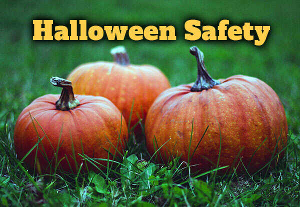 Three pumpkins sitting in grass with the text, Halloween Safety.